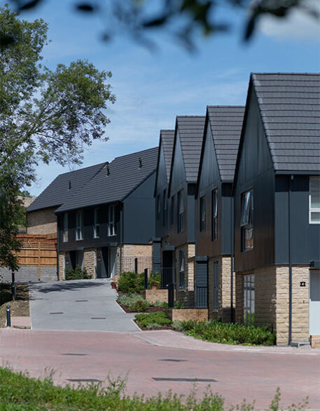 An external shot of multiple Keld developments with a driveway leading up to them from the road.